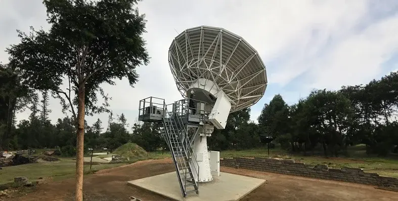 This solution offers a secure, stable, and high-performance primary connectivity network, crucial for engineering private networks or leveraging cloud-based applications. (Image source: Avanti Communications) A large satellite set up pointing at the sky in a wooded area.