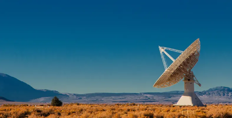 Satellite dish facing the sky placed on an open ground 