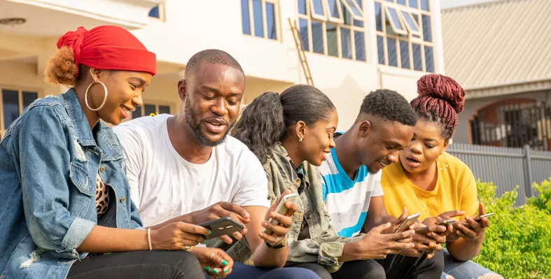 A group of youngsters hanging out while using their mobile phones