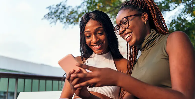 Two young women with a mobile phone