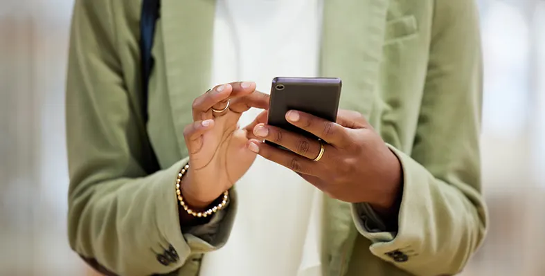 Woman’s hands texting, networking, or browsing on smartphone