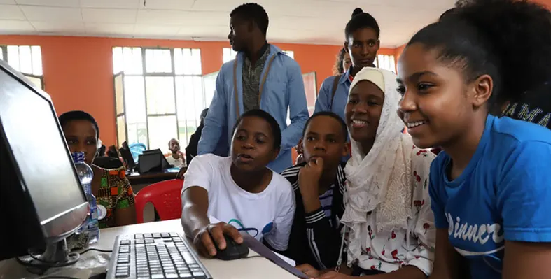 Students gathered around to use computer 