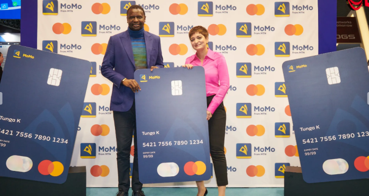 Senior executives from MTN and Mastercard posing with a large bank card.