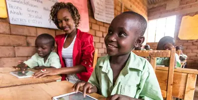 Small boy with tablet at a school desk.